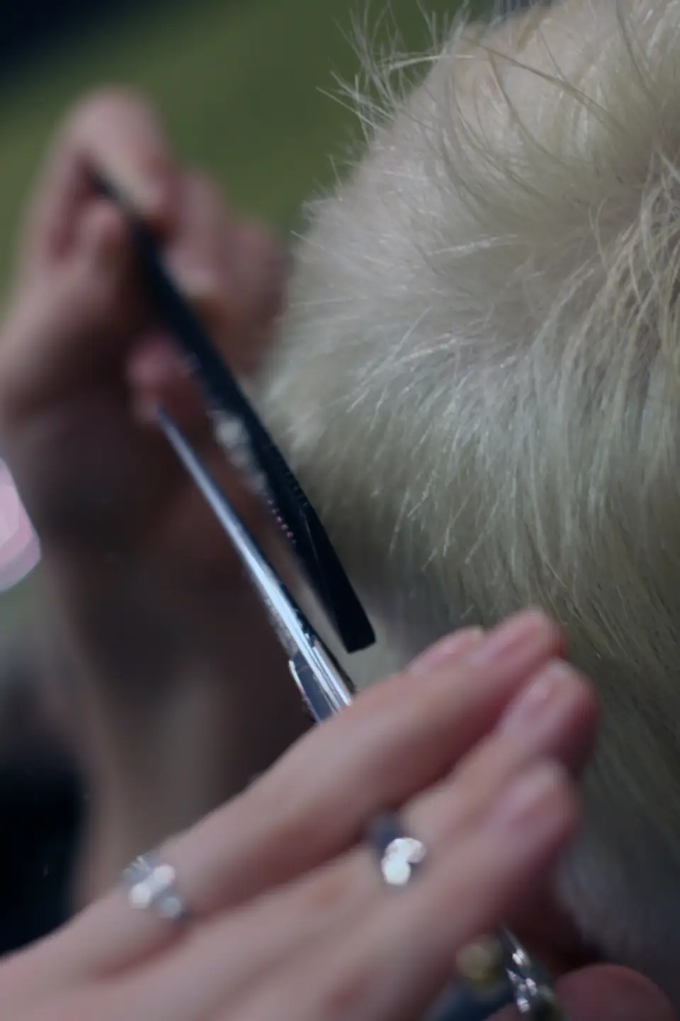 Barber trimming a customer’s hair with scissors