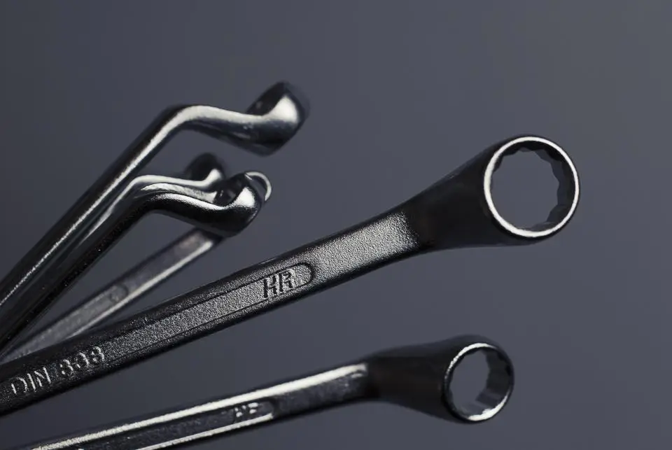 Set of steel wrenches laid out on a dark work surface